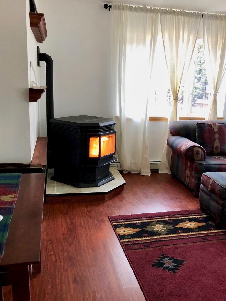 A living room with wood burning stove and couch
